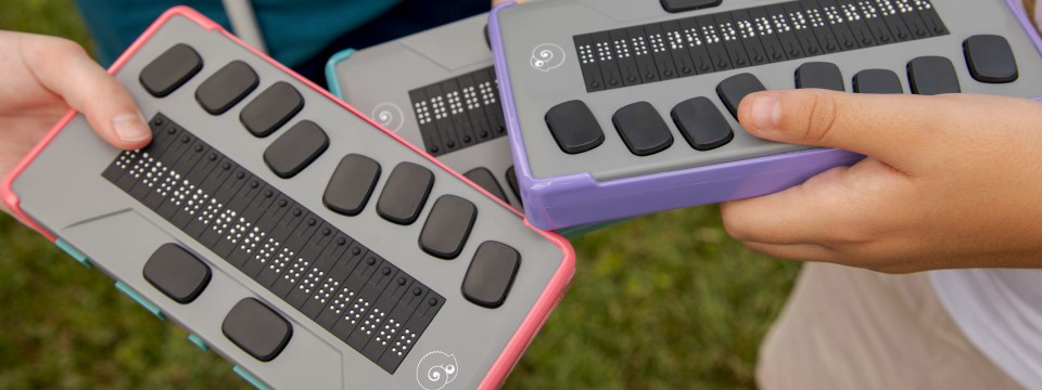 Three kids each holding a chameleon in a different color bumper case. The color of the cases are light pink, light purple, and light blue.