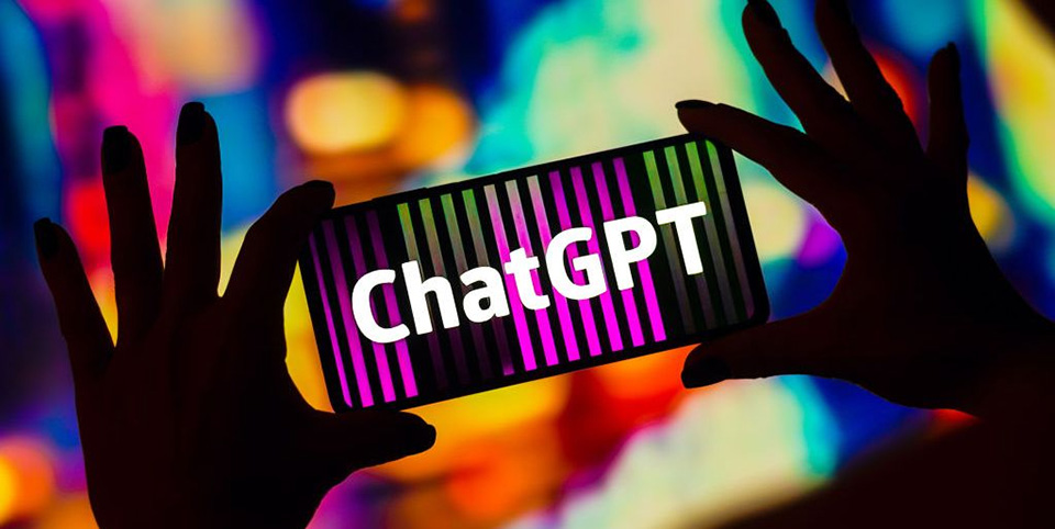 ChatGPT logo shows on a phone in landscape mode. The silhouette of two hands hold the phone against a bright, colorful background.