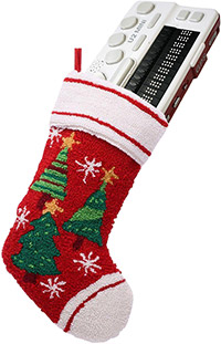 Photo of a red, quilted Christmas stocking adorned with Christmas trees and snow flakes hanging from a string with a BrailleSense U2 Mini 18 Cell Notetaker sticking out of the top of it.