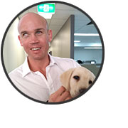 Photo of Ben Moxey holding Ferris, Guide Dog in Training.